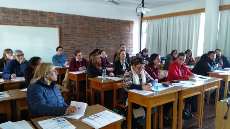 Salon de clases con personas escribiendo sentadas 