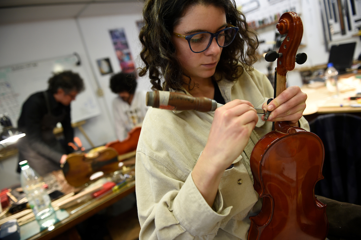 mujer fabricando instrumento musical